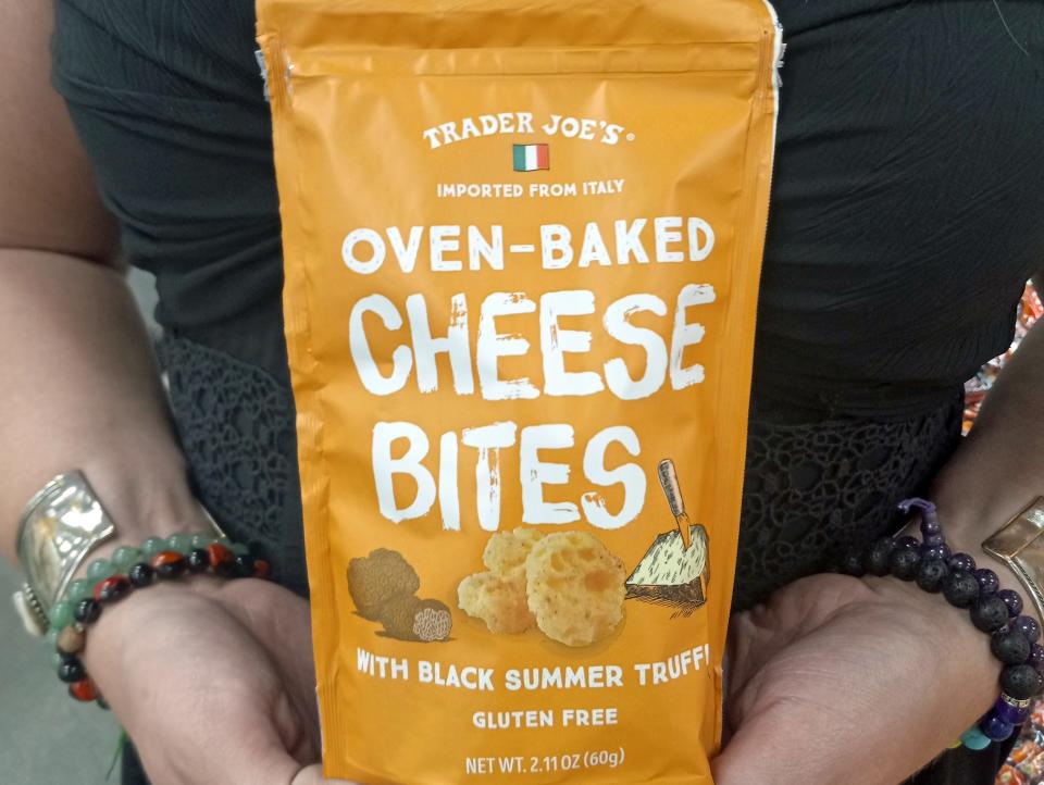woman holding a package of cheese bites at trader joes