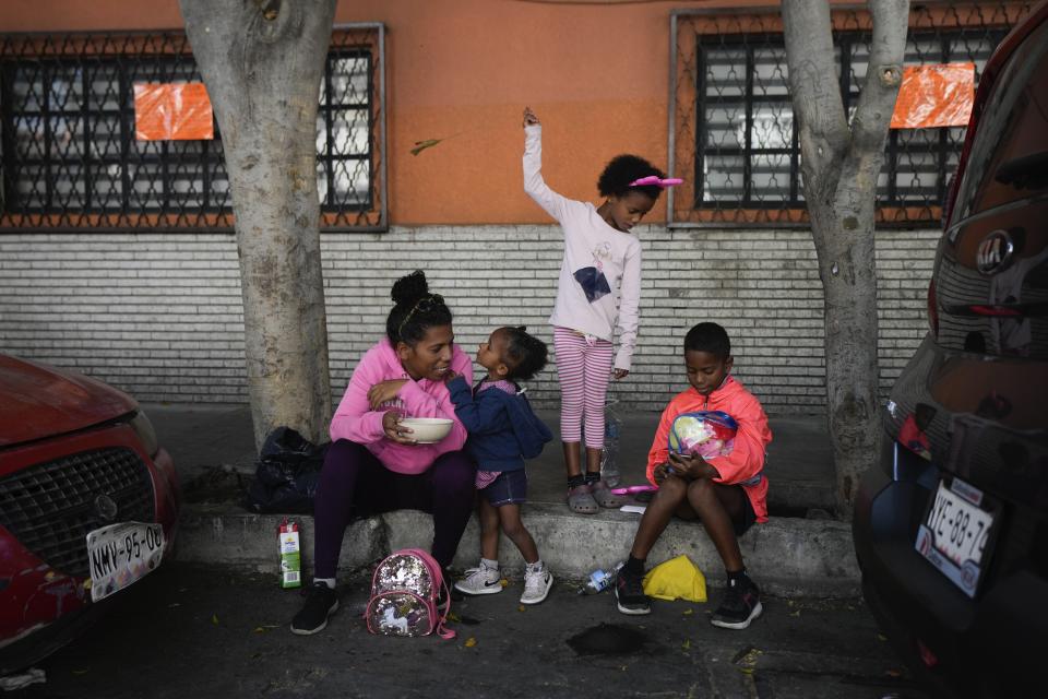 A migrant family from Venezuela has breakfast alongside the railroad tracks lined with makeshift tents in Mexico City, Tuesday, March 26, 2024. (AP Photo/Fernando Llano)