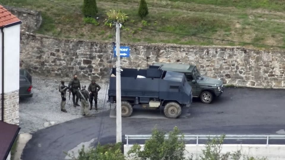 Kosovo Police and a group of armed, masked men stand in front of the Banjska Monastery in North Kosovo. - Kosovo Police/AP