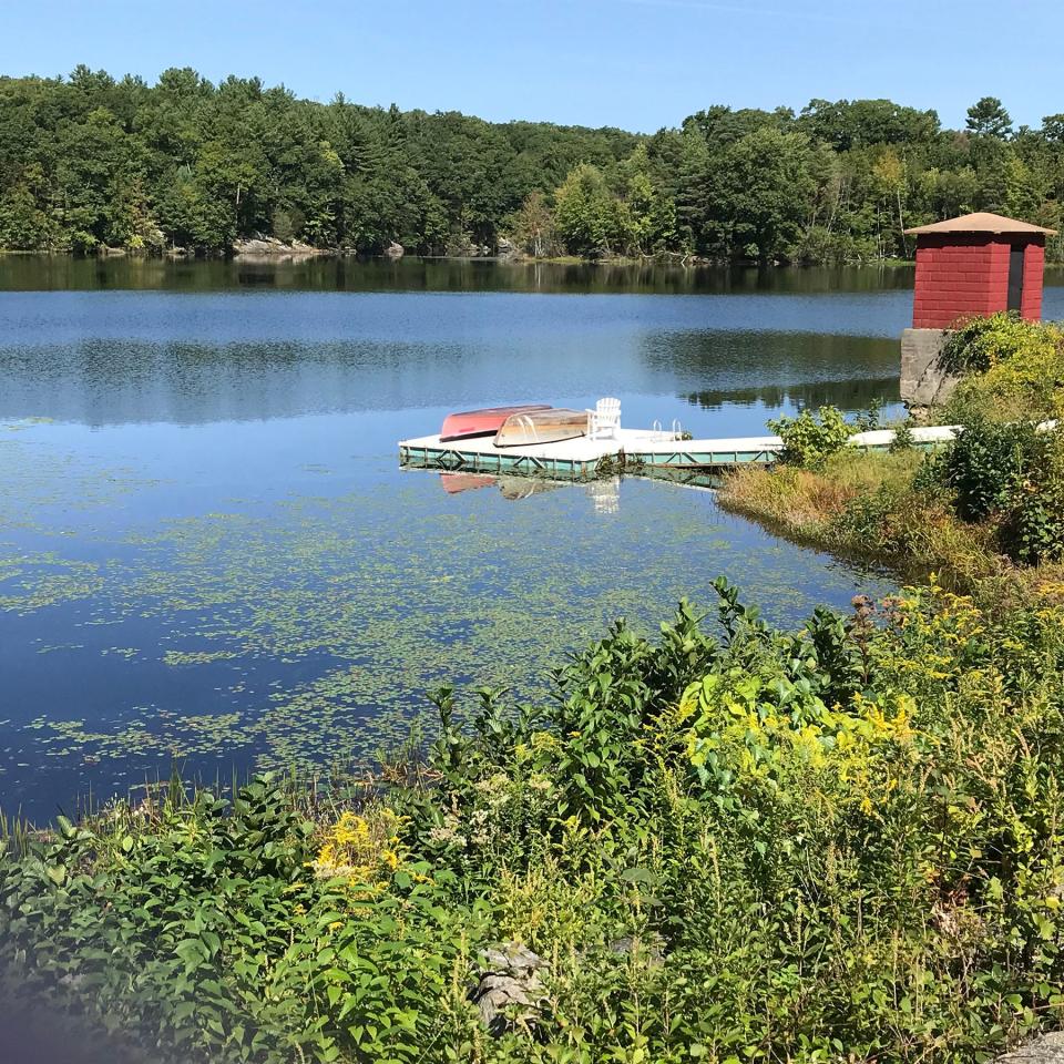 A dock and cement-block gatehouse are just off an earthen dam that holds back water to form the Sprague Upper Reservoir.  