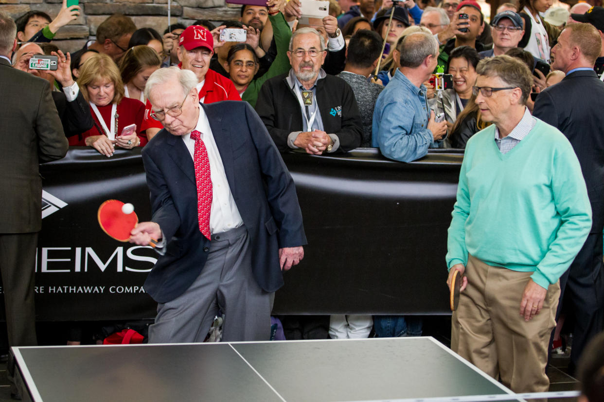 Berkshire Hathaway Chairman and CEO Warren Buffett, left, and Microsoft co-founder Bill Gates play table tennis against prodigy Ariel Hsing, unseen, outside the Borsheims jewelry store, a Berkshire Hathaway subsidiary, in Omaha, Neb., Sunday, May 1, 2016. The annual Berkshire shareholders weekend is coming to a close one day after more than 40,000 people attended a question and answer session with Warren Buffett and his Vice Chairman Charlie Munger. (AP Photo/John Peterson)