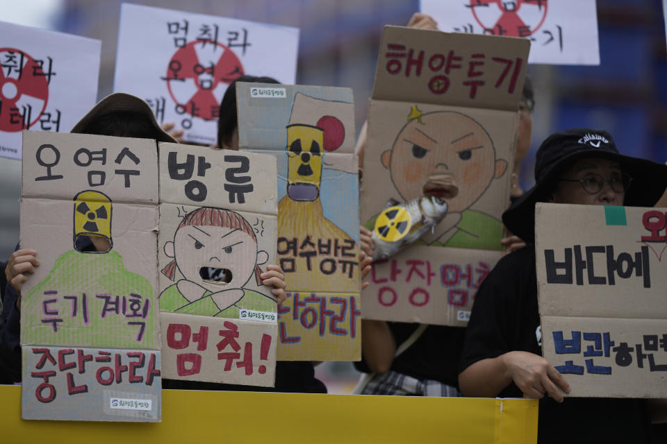 Members of an environmental group shout slogans during a rally to demand the stop of the Japanese government's decision to release treated radioactive water into the sea from the damaged Fukushima nuclear power plant, in Seoul, South Korea, Thursday, Aug. 24, 2023. The letters read " Stop to release radioactive water." (AP Photo/Lee Jin-man)