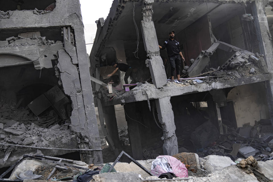 Palestinians look for survivors in a building destroyed in Israeli bombardment in Rafah refugee camp in Gaza Strip on Tuesday, Oct. 17, 2023. (AP Photo/Fatima Shbair)