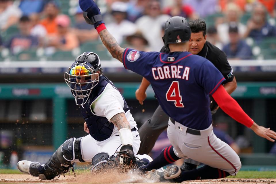Minnesota Twins' Carlos Correa beats the tag of Detroit Tigers catcher Eric Haase to score during the first inning of a baseball game, Sunday, July 24, 2022, in Detroit.