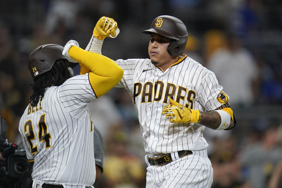 San Diego Padres' Manny Machado, right, celebrates with teammate Josh Bell after hitting a home run during the sixth inning of a baseball game against the Los Angeles Dodgers, Saturday, Sept. 10, 2022, in San Diego. (AP Photo/Gregory Bull)