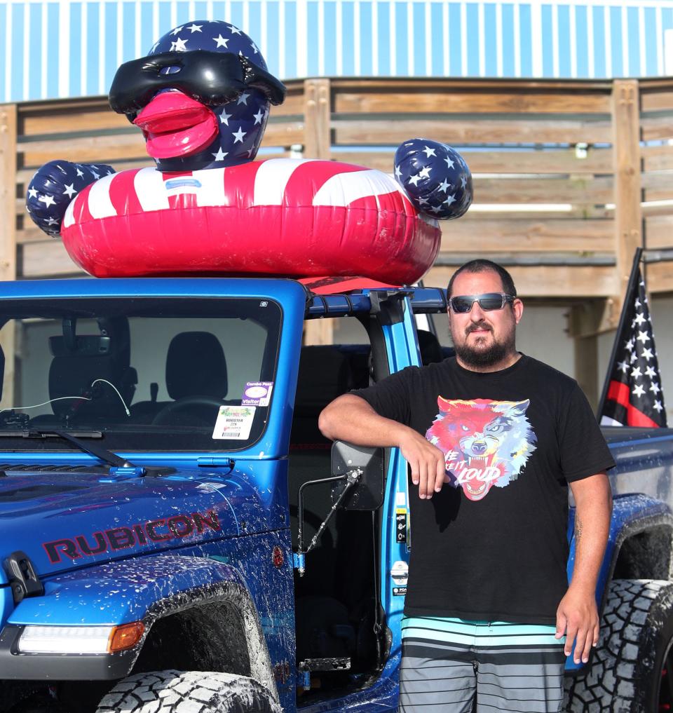 Jeep owner Blake Jacobs, of Charlotte, North Carolina, poses with the oversized duck that rides on the roof of his 2022 Galdiator Rubicon at this year's Jeep Beach. It's a tribute to law enforcement and firefighters, he said.