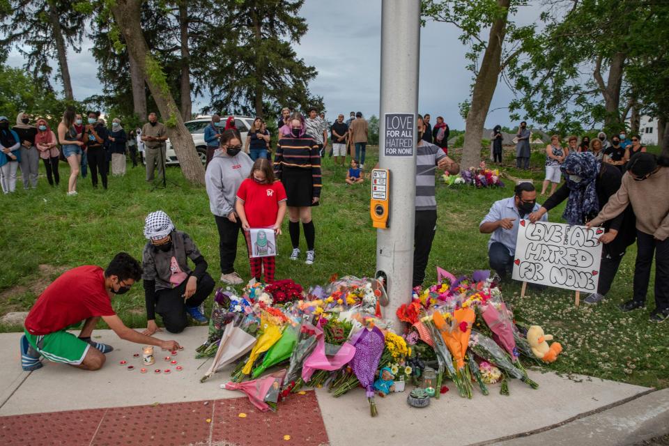 People attend a memorial at the location where a family of five was hit by a driver, in London, Ontario, Monday, June 7, 2021. Four of the members of the family died and one is in critical condition. A 20-year-old male has been charged with four counts of first degree murder and count of attempted murder in connection with the crime.