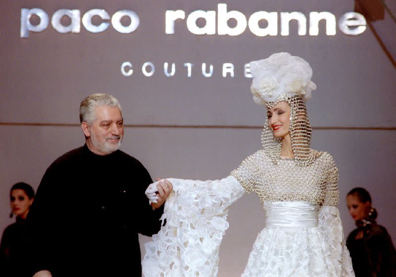 FILE PHOTO: French Fashion designer Paco Rabanne stands with one of his models at the finale of his show at the ..