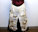 A woman on a flight from Singapore to Melbourne shows the 51 live tropical fish hidden in a specially designed apron under her skirt in this handout photograph from the Australian Customs Service on June 3, 2005. Customs officers became suspicious after hearing "flipping" noises coming from the vicinity of her waist, and an examination revealed 15 plastic water-filled bags holding concealed fish. Picture taken June 3, 2005. REUTERS/Handout/Australian Customs Service DG/SA