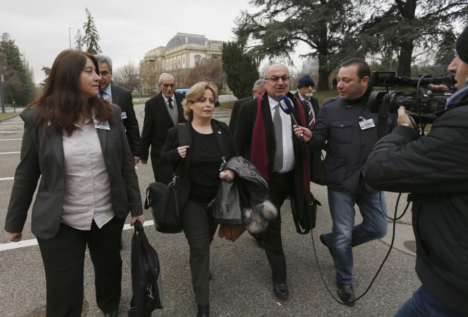 Members of Syrian opposition delegation Rima Fleihan (L), and Suheir Attasi (2nd L) and Abdulahad Astepho (3rd L) speak to a journalist as they arrive for their first meeting face to face with Syrian government delegation and U.N.-Arab League envoy for Syria Lakhdar Brahimi (not pictured) at a U.N. office in Geneva January 25, 2014. Syria's civil war foes held their first meeting in the same room in the presence of international mediator Brahimi on Saturday after a day's delay and fierce recriminations. The talks in Geneva aimed to launch political negotiations on ending Syria's nearly three-year conflict, which has killed 130,000 people, displaced over third of Syria's 22 million population and destabilized the wider region. REUTERS/Jamal Saidi (SWITZERLAND - Tags: POLITICS CONFLICT CIVIL UNREST MEDIA)