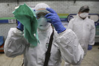 A workers wearing protective gears adjusts her glasses while she prepares to spray disinfectant as a precaution against the coronavirus at a subway station in Seoul, South Korea, Friday, Feb. 21, 2020. South Korea on Friday declared a "special management zone" around a southeastern city where a surging viral outbreak, largely linked to a church in Daegu, threatens to overwhelm the region's health system. (AP Photo/Ahn Young-joon)