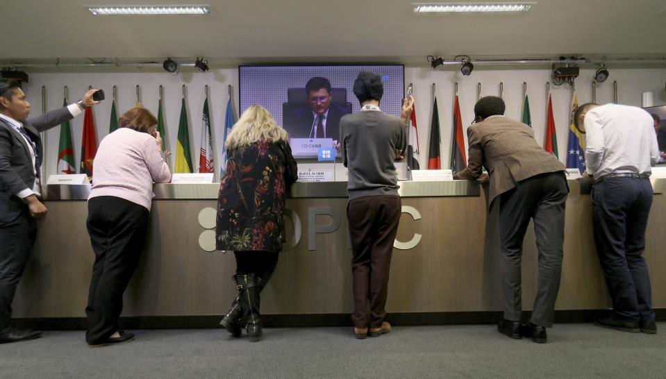Journalists listen to a video during a meeting of the Organization of the Petroleum Exporting Countries, OPEC, and non OPEC members, at their headquarters in Vienna, Austria, Friday, Dec. 7, 2018. (AP Photo/Ronald Zak)
