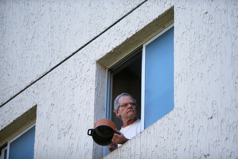 Un manifestante golpea una olla en una ventana de su casa para protestar contra el presidente de Brasil, Jair Bolsonaro, en el barrio Sudoeste de Brasilia, en medio del brote de la enfermedad por coronavirus (COVID-19), en Brasilia.