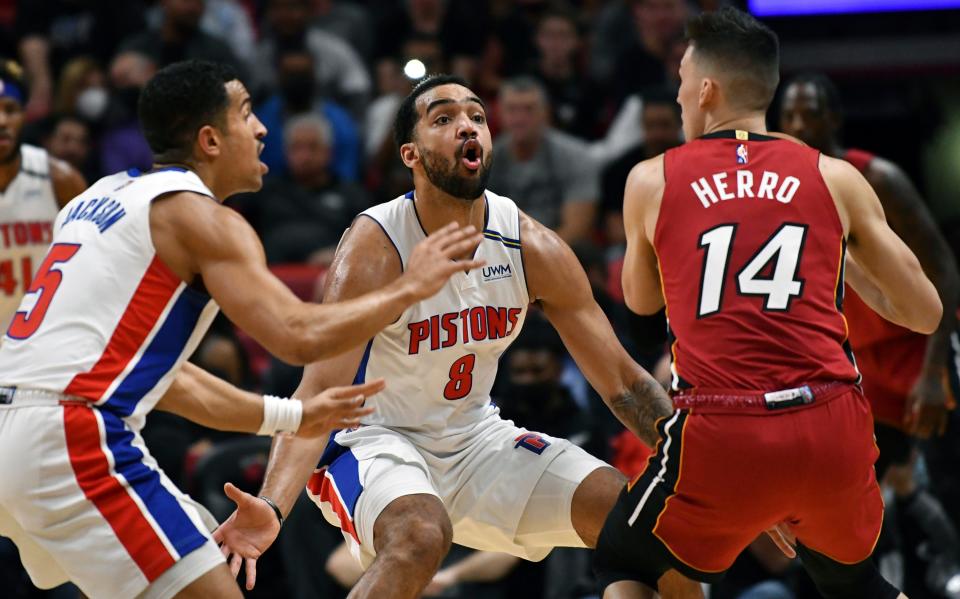 Detroit Pistons forward Trey Lyles (8) and teammate guard Frank Jackson (5) defend Miami Heat guard Tyler Herro (14) during the first half on Thursday, Dec. 23, 2021, at FTX Arena in Miami.