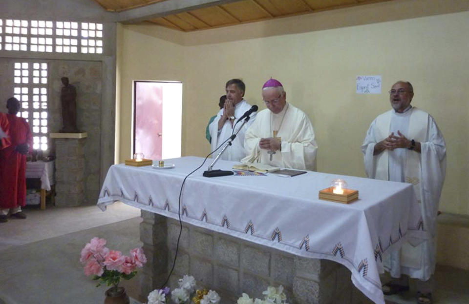 This photo released by Vicenza Diocese, Saturday April 5, 2014 shows Vicenza Bishop Beniamino Pizziol, center, flanked by father Gianantonio Alllegri, right, and Giampaolo Marta, left, during a mass in Tchakidjebe church, near Maroua, Cameroon, during a visit on Jan. 2014. Officials say two Italian priests and a Canadian nun working as missionaries in northern Cameroon have been abducted. Italy's foreign ministry said the abduction occurred during the night between Friday and Saturday about 30 kilometers (20 miles) from the border with Nigeria. It identified the priests as Giampaolo Marta and Gianantonio Allegri, but declined to give other details, including the Canadian's identity, to avoid compromising efforts for the missionaries' release.( AP Photo/Vicenza Diocese)