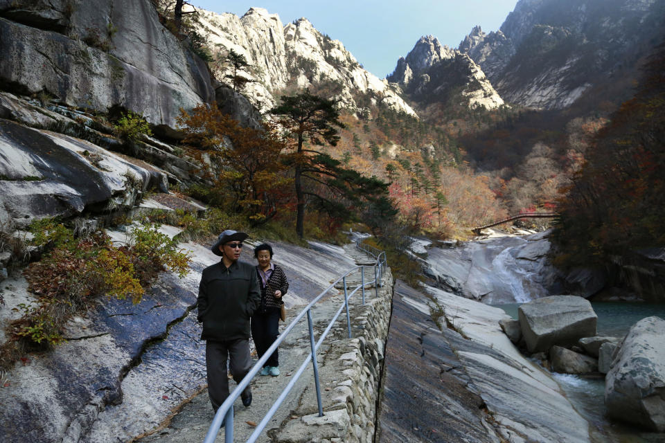 FILE - In this Oct. 23, 2018, file photo, local tourists walk on the trail at Mount Kumgang, known as Diamond Mountain, in North Korea. North Korea on Friday, Nov. 15, 2019, said it issued an ultimatum to South Korea that it will tear down South Korean-made hotels and other facilities at the North’s Diamond Mountain resort if the South continues to ignore its demands to come and clear them out. (AP Photo/Dita Alangkara, File)