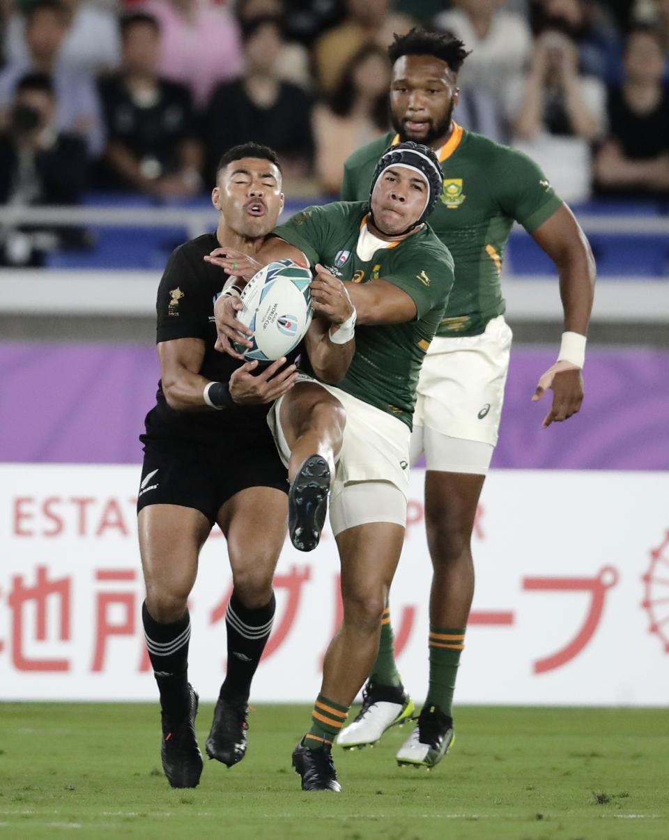 South Africa's Cheslin Kolbe, right, competes with New Zealand's Richie Mo'unga to take the ball during the Rugby World Cup Pool B game at International Stadium between New Zealand and South Africa in Yokohama, Japan, Saturday, Sept. 21, 2019. (AP Photo/Jae Hong)