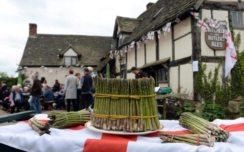 Freshly cut rounds of asparagus are tied as people celebrate St George's Day and the official start of the asparagus season at the The Fleece Inn in Bretforton, Worcestershire. - Credit: Joe Giddens/PA