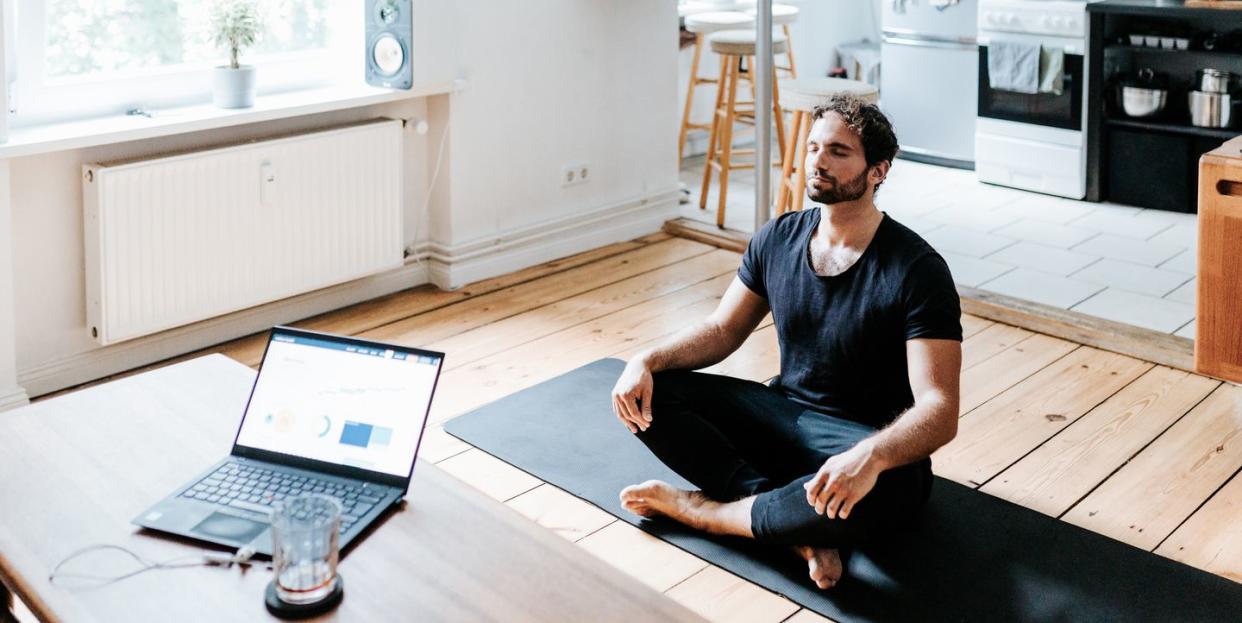 adult man meditates at home office during a break from working