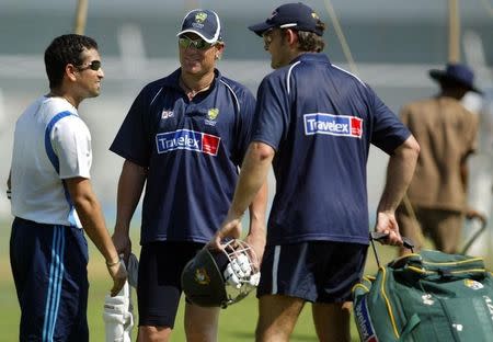 Indian cricket star Sachin Tendulkar speaks with Australia's Shane Warne (C) and Adam Gilchrist (R) after a training session in Mumbai September 29, 2004. REUTERS/Punit Paranjpe/Files