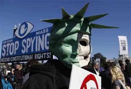 A protester wears a mask depicting a skull beneath the head of the Statue of Liberty, as he demonstrates during the "Stop Watching Us: A Rally Against Mass Surveillance" near the U.S. Capitol in Washington, October 26, 2013. REUTERS/Jonathan Ernst