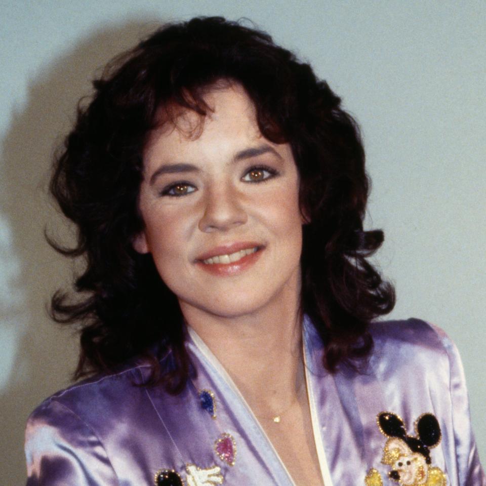 Stockard standing in a satin jacket with Mickey Mouse designs, smiling