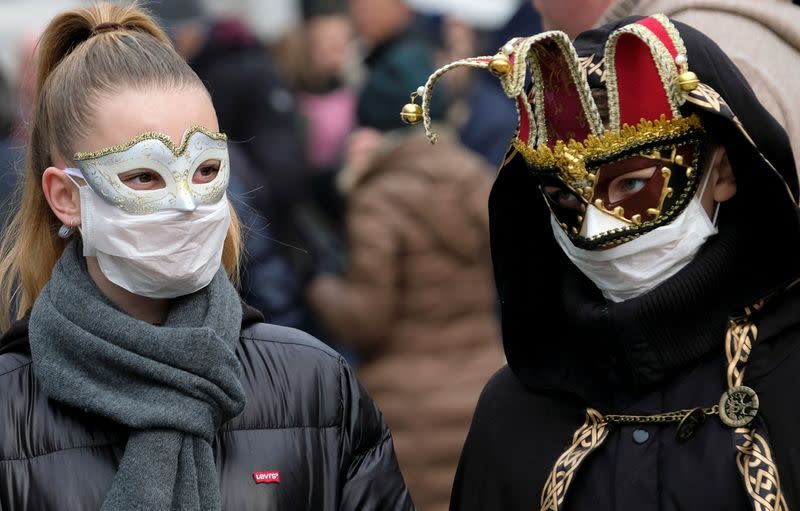 Masked carnival revellers wear protective face masks at Venice Carnival