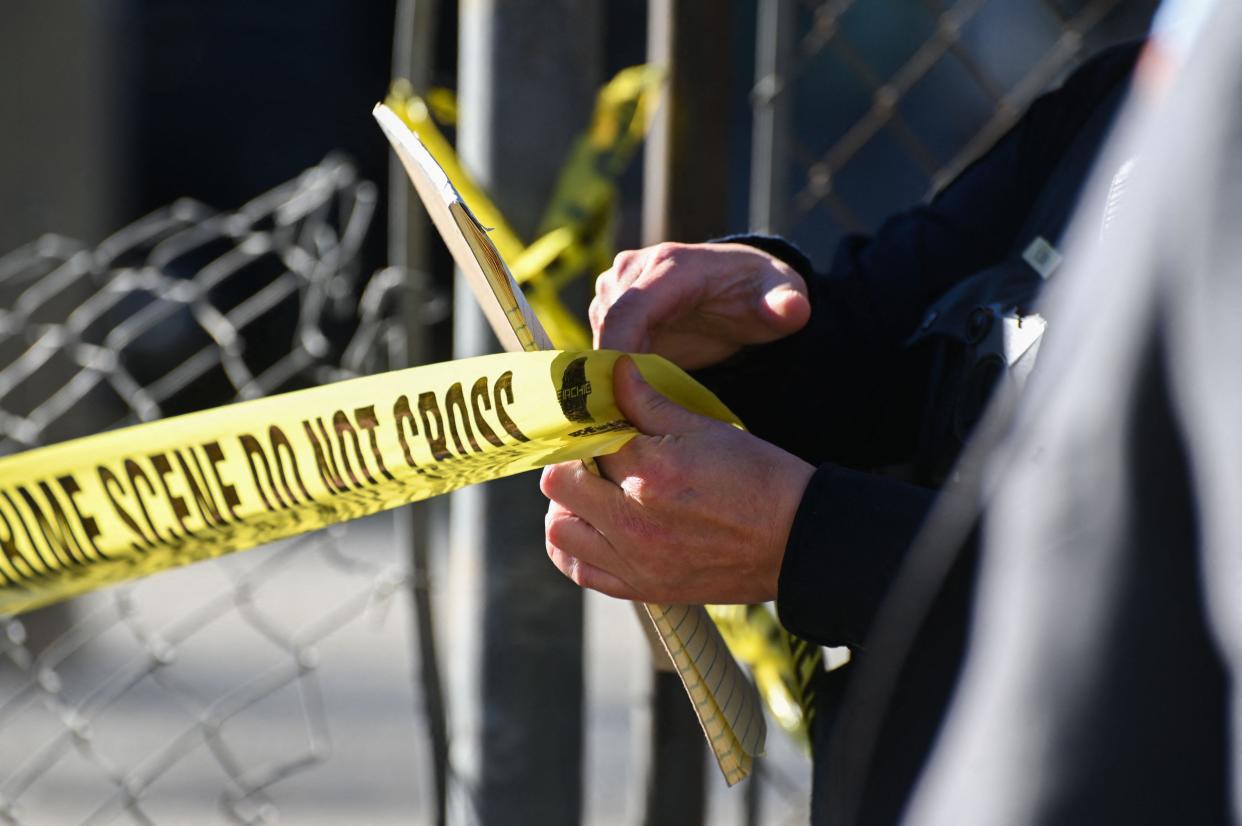 A San Mateo County Sheriff officer puts up police tape at a crime scene after a shooting at the Spanish Town shops in Half Moon Bay, California, on January 24, 2023. - A suspected gunman was in custody Monday over the killing of seven people in a rural community in northern California, just two days after a mass shooting at a Lunar New Year celebration near Los Angeles. 