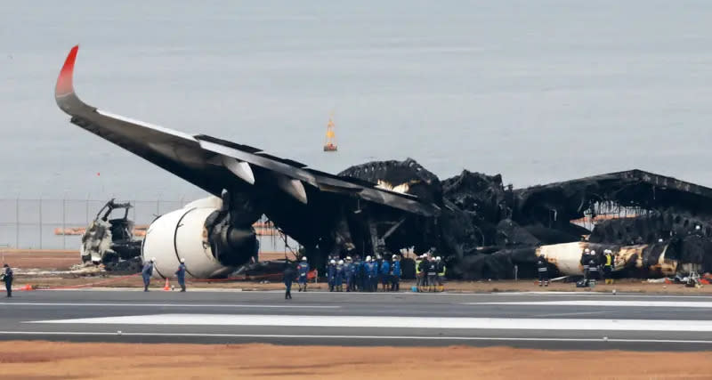 ▲一架日本航空客機，2日下午在羽田機場降落時，與準備運送賑災物資的海上保安廳飛機相撞起火，機體被燒成炭黑色。（圖／美聯社／達志影像）