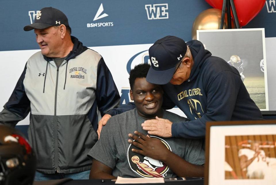 Central Catholic’s Manasse Itete is embraced by coach Myron Larson during a National Signing Day ceremony at Central Catholic High School in Modesto, Calif., Wednesday, Dec. 20, 2023. Itete signed to play football at Florida State University.