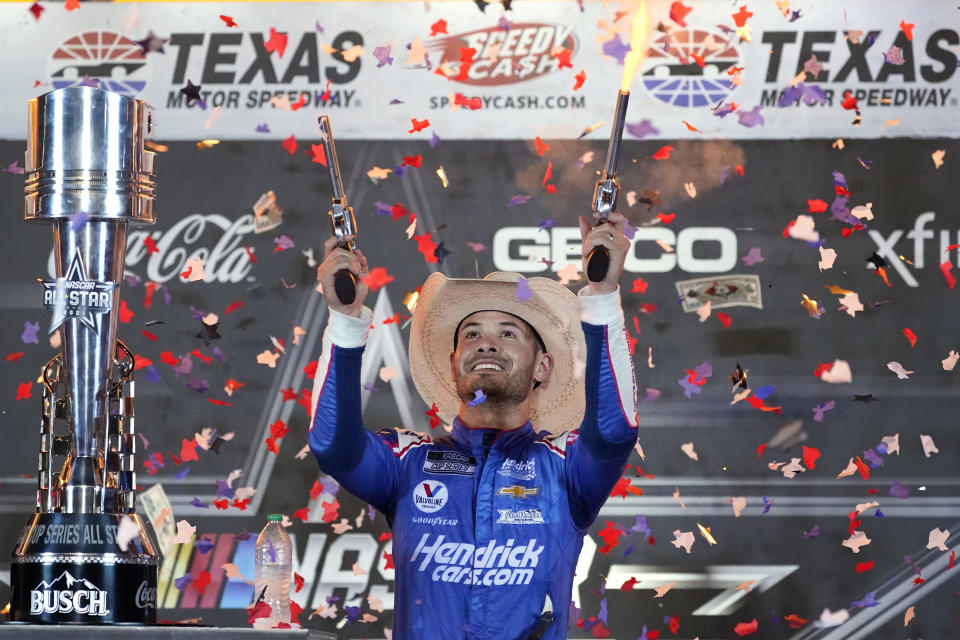 Kyle Larson shoots pistols as he celebrates in Victory Lane after winning the NASCAR Cup Series All-Star auto race at Texas Motor Speedway in Fort Worth, Texas, Sunday, June 13, 2021. (AP Photo/Tony Gutierrez)