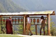 Britain's Prince William (C), Duke of Cambridge and his wife Catherine (R), Duchess of Cambridge, spin prayer wheels as Khenpo Phuntsok Tashi, Director of Bhutan's National Museum, looks on at the Paro Taktsang Monastery, Bhutan, April 15, 2016. REUTERS/Cathal McNaughton