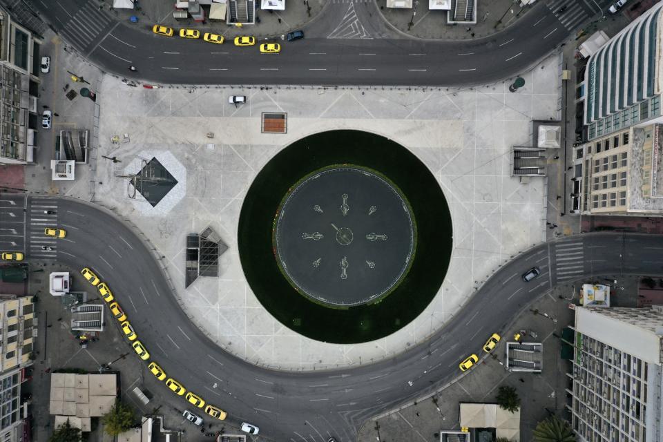 In this Wednesday, April 1, 2020 aerial photo, a view of the worksite of the new fountain in Omonoia square as taxis line-up in central Athens during the lockdown. Deserted squares, padlocked parks, empty avenues where cars were once jammed bumper-to-bumper in heavy traffic. The Greek capital, like so many cities across the world, has seen its streets empty as part of a lockdown designed to stem the spread of the new coronavirus. (AP Photo/Thanassis Stavrakis)