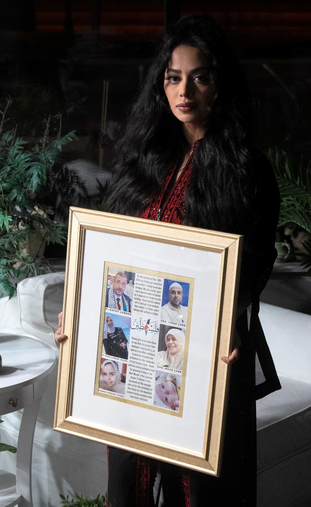 Rosan Eldadah holds a framed photo Monday showing members of her family (two uncles, an aunt and three cousins) who she says were killed following air strikes to the building where they lived in Gaza.