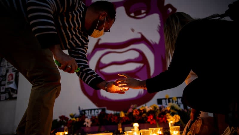 Rob Hall and Misti Western light candles in front of a mural of George Floyd in Salt Lake City after a jury found former Minneapolis police officer Derek Chauvin guilty in the killing of Floyd on Tuesday, April 20, 2021. May 25, 2024, marks the four-year anniversary of Floyd’s murder in Minneapolis.