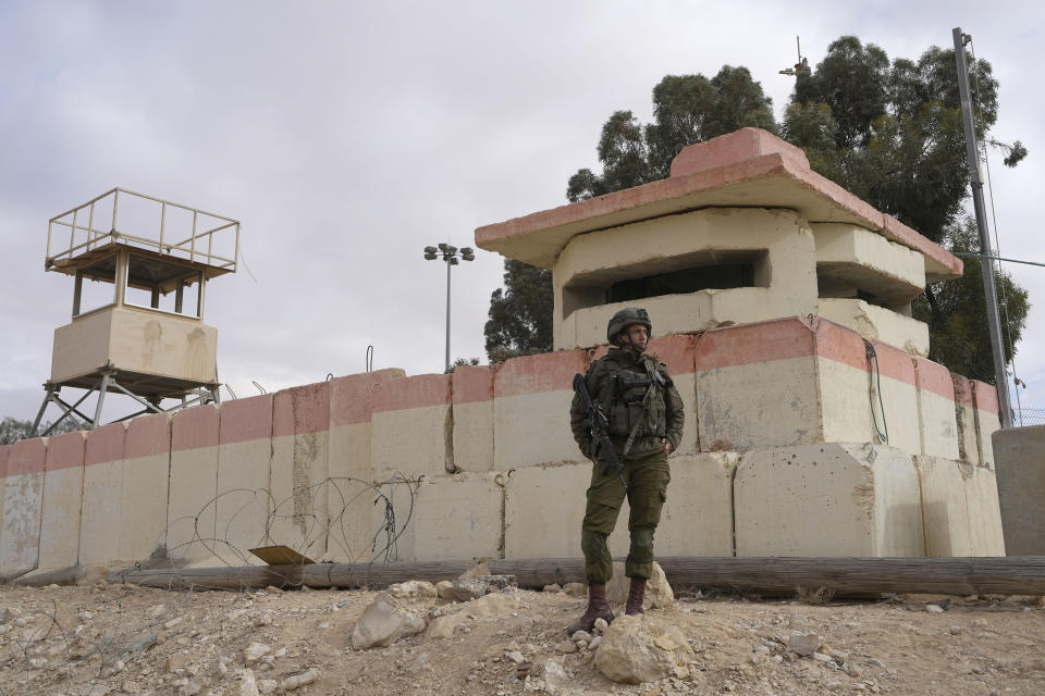 An Israeli soldier watches protesters block the path for humanitarian aid bound for the Gaza Strip at the Nitzana border crossing with Egypt in southern Israel Friday, Feb. 2, 2024. (AP Photo/Tsafrir Abayov)