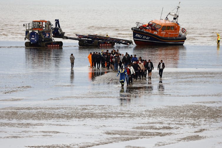 Asylum seekers arrive on a beach in Kent after being rescued by RNLI boats