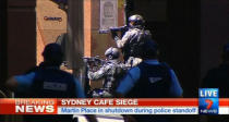 Armed police take up position near Lindt cafe in Sydney's Martin Place, where hostages are being held, in this still image taken from video from Australia's Seven Network on December 15, 2014. REUTERS/Reuters TV via Seven Network/Courtesy Seven Network