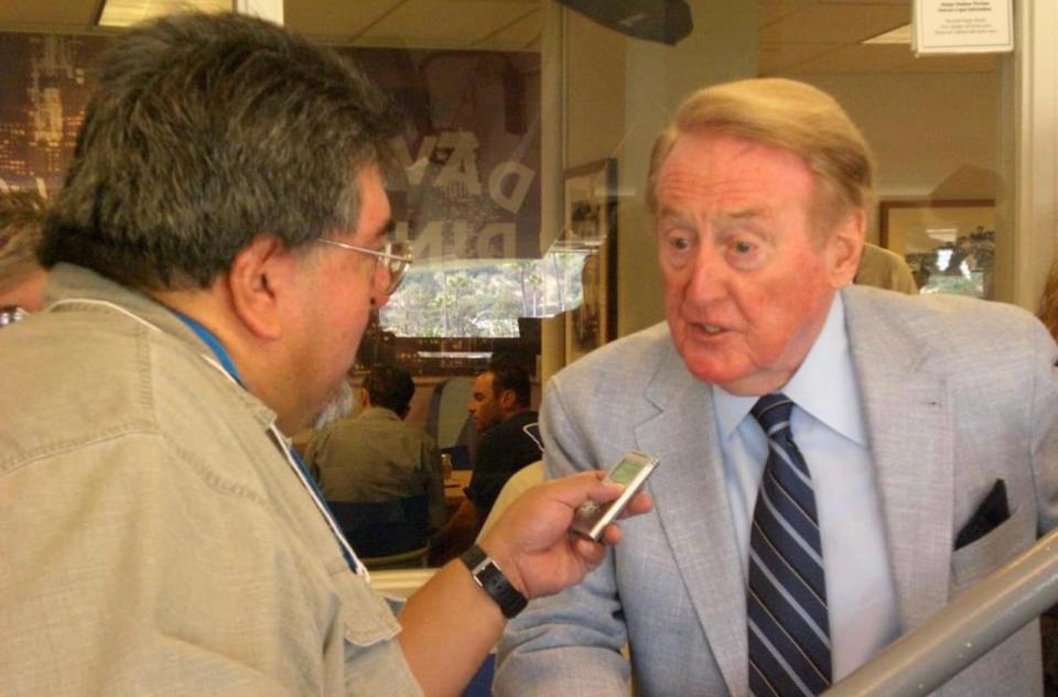 Reporter Rene Ray De La Cruz interviews the late Vin Scully, the Hall of Fame broadcaster of the Los Angeles Dodgers, who died on Tuesday. He was 94.