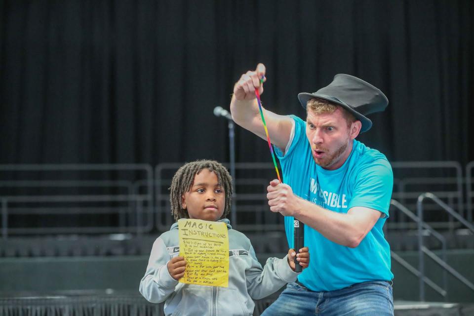 A student from White Bluff Elementary assists the magician with a trick on Tuesday, October 17, 2023 during a reading rally at Enmarket Arena.
