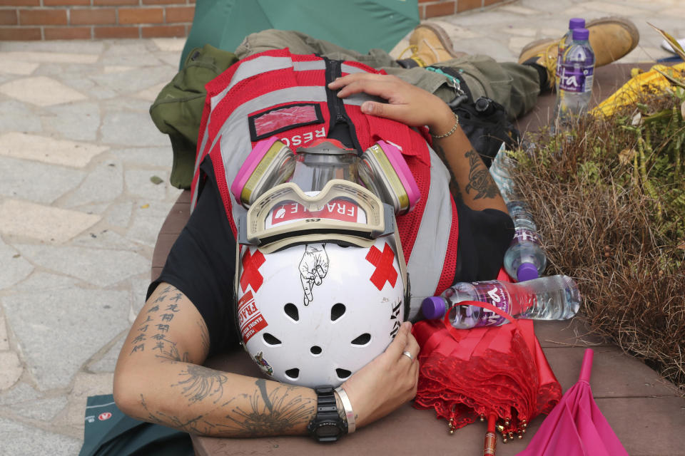 A volunteer first aid medic rests at the Hong Kong Polytechnic University in Hong Kong, Thursday, Nov. 14, 2019. University students from mainland China and Taiwan are fleeing Hong Kong, while those from three Scandinavian countries have been moved or urged to leave as college campuses become the latest battleground in the city's 5-month-long anti-government unrest. (AP Photo/Ng Han Guan)