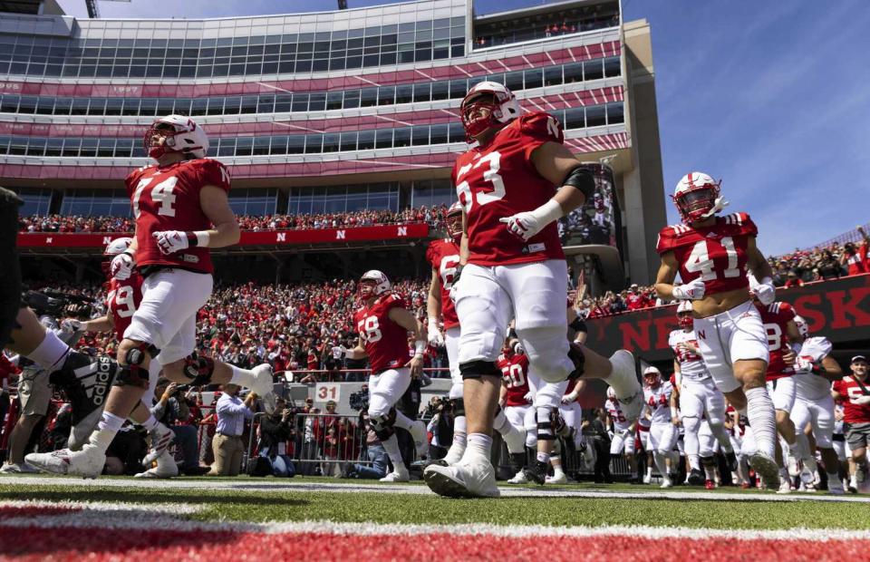 Nebraska players run onto the field at Memorial Stadium in Lincoln before their spring game in April.