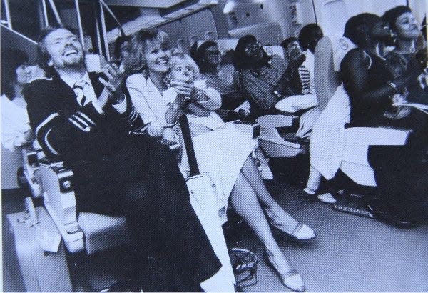 A photo of Richard Branson on board Virgin Atlantic's maiden flight in 1984 sitting beside his wife Joan with their daughter Holly on her lap.