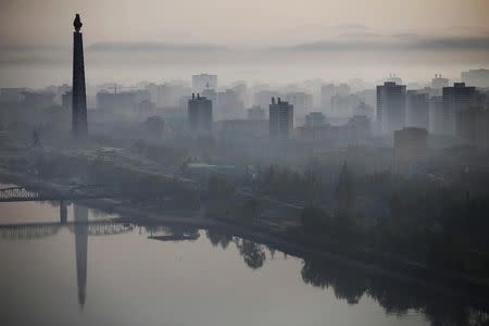 The 170-metre (558-feet) tall Juche Tower is reflected in Taedong River as morning fog blankets Pyongyang, North Korea May 5, 2016. REUTERS/Damir Sagolj