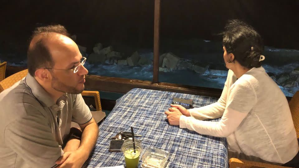 In this image, taken by Ra Page, Alareer (left) can be seen sitting opposite Page's wife, Basma el Farra (right), at a restaurant bar called el-Bakka, during their last night together in Gaza City, in August 2022. - Courtesy Ra Page