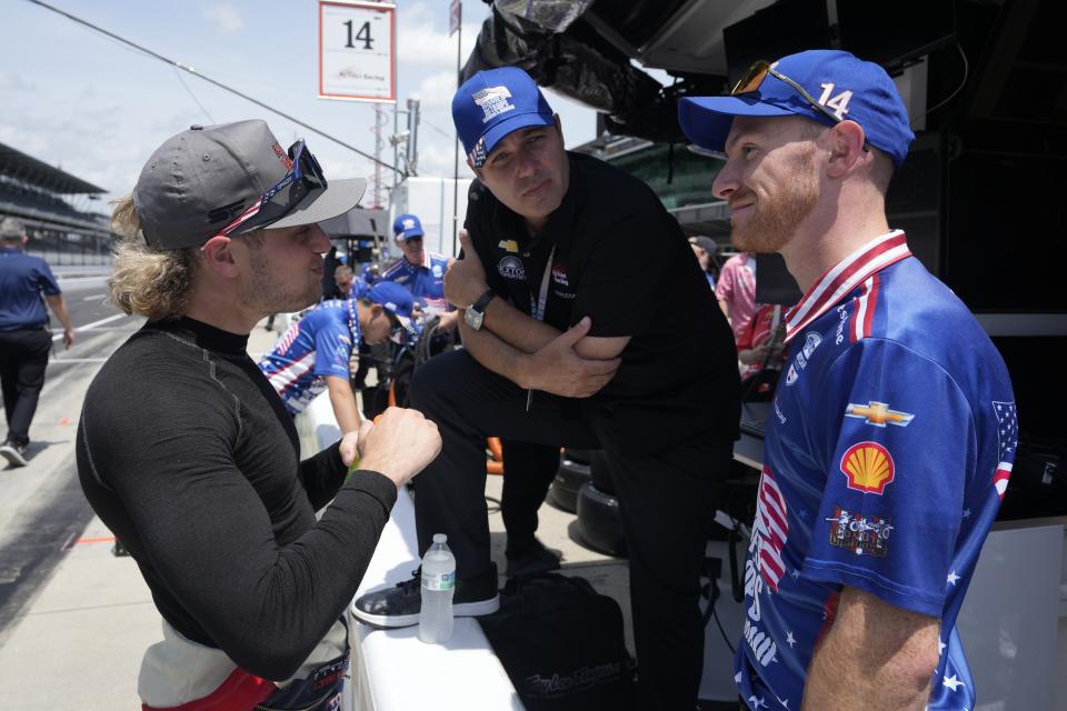 Santino Ferrucci, left, talks with his crew following a practice session for the Indianapolis 500 auto race at Indianapolis Motor Speedway, Friday, May 24, 2024, in Indianapolis. (AP Photo/Darron Cummings)