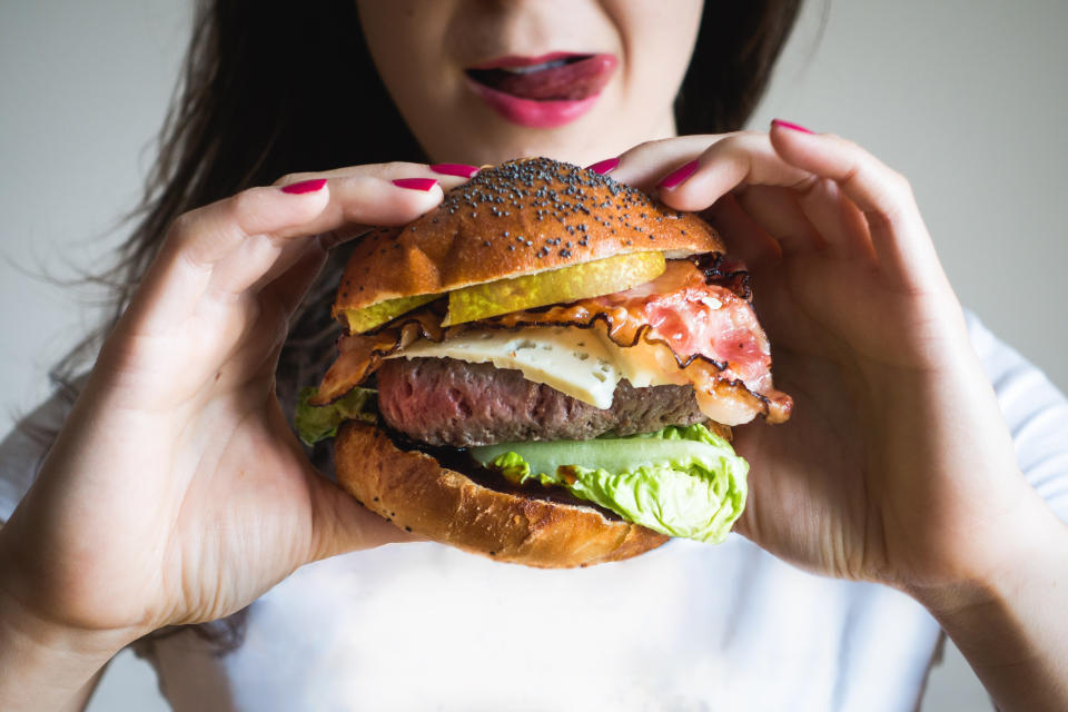 Midsection Of Woman Holding Burger
