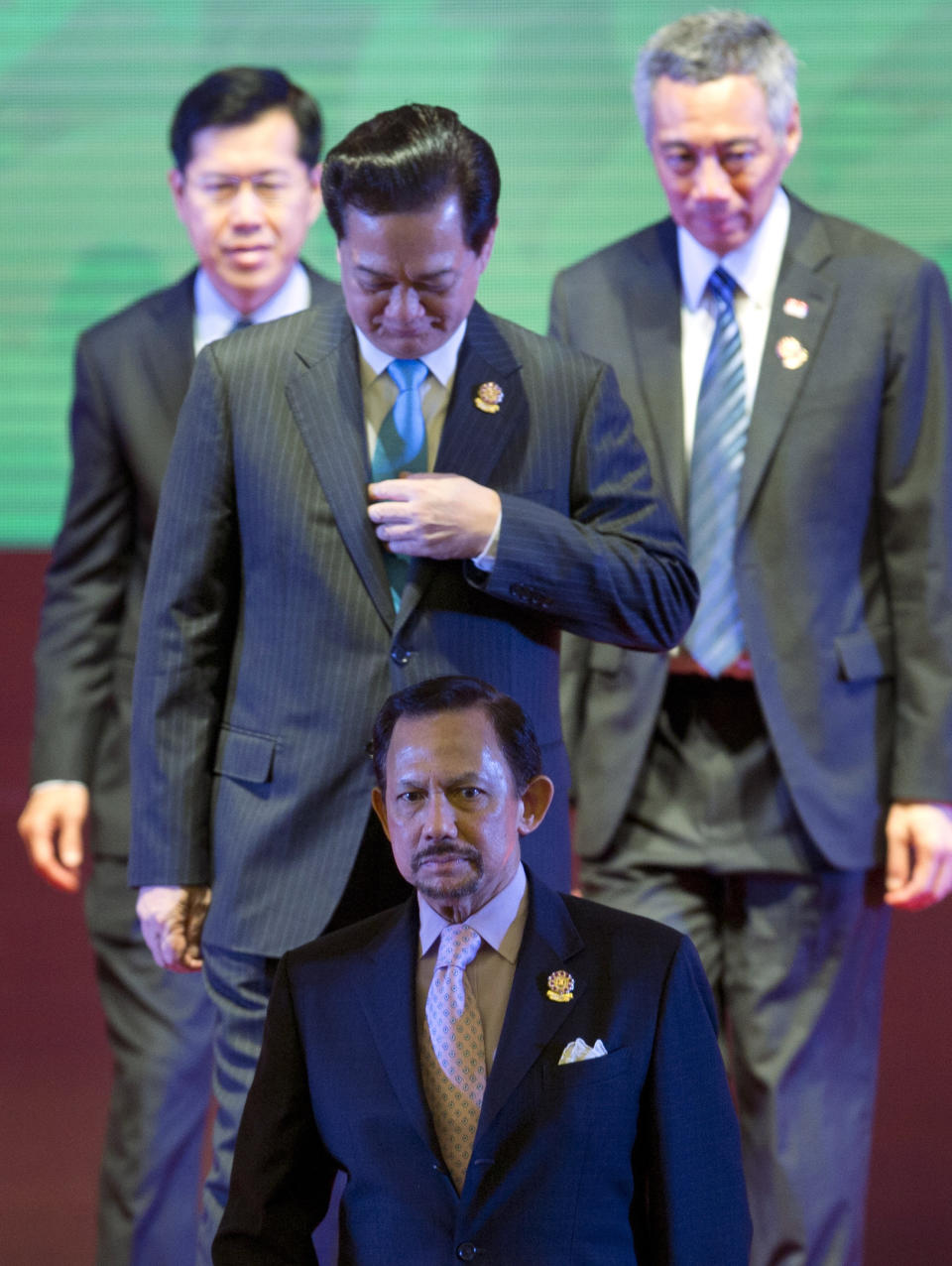 Sultan of Brunei Hassanal Bolkiah, foreground, walks away with a group of leaders of the Association of Southeast Asian Nations after posing for a photograph during the 24th ASEAN leaders Summit in Naypyitaw, Myanmar, Sunday, May 11, 2014.(AP Photo/Gemunu Amarasinghe)