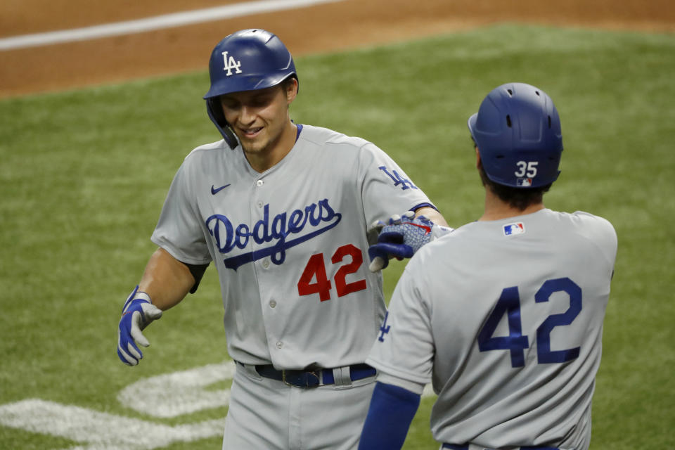 Los Angeles Dodgers' Corey Seager, left, is congratulated by Cody Bellinger, right, after a solo home run during the first inning of a baseball game against the Texas Rangers in Arlington, Texas, Sunday, Aug. 30, 2020. (AP Photo/Roger Steinman)