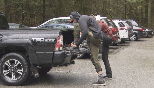 Two people get ready for a hike at Lynn Headwaters Regional Park. On March 29, 2021, Metro Vancouver will charge $2 per hour for parking to try to ease congestion at the park. (Jon Hernandez/CBC News - image credit)